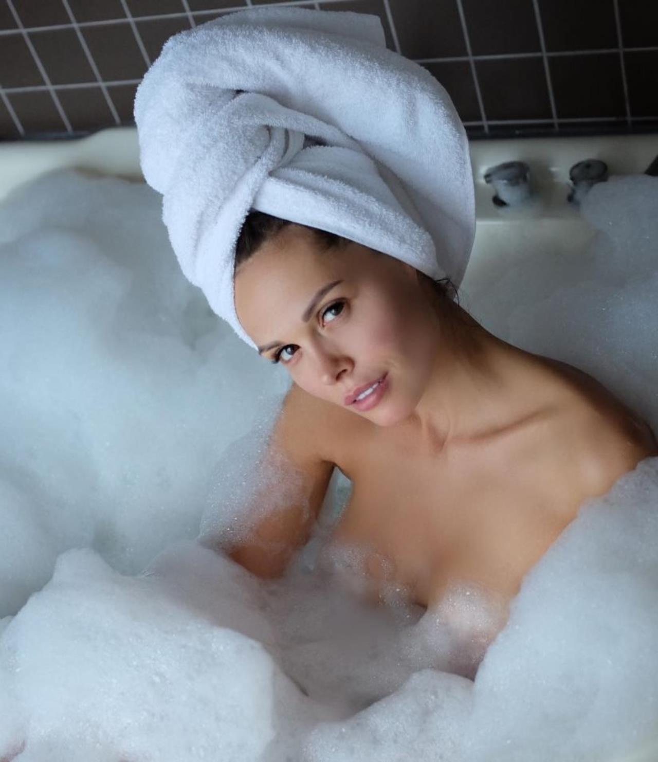 Молодая девушка в ванной вытерла себя полотенцем