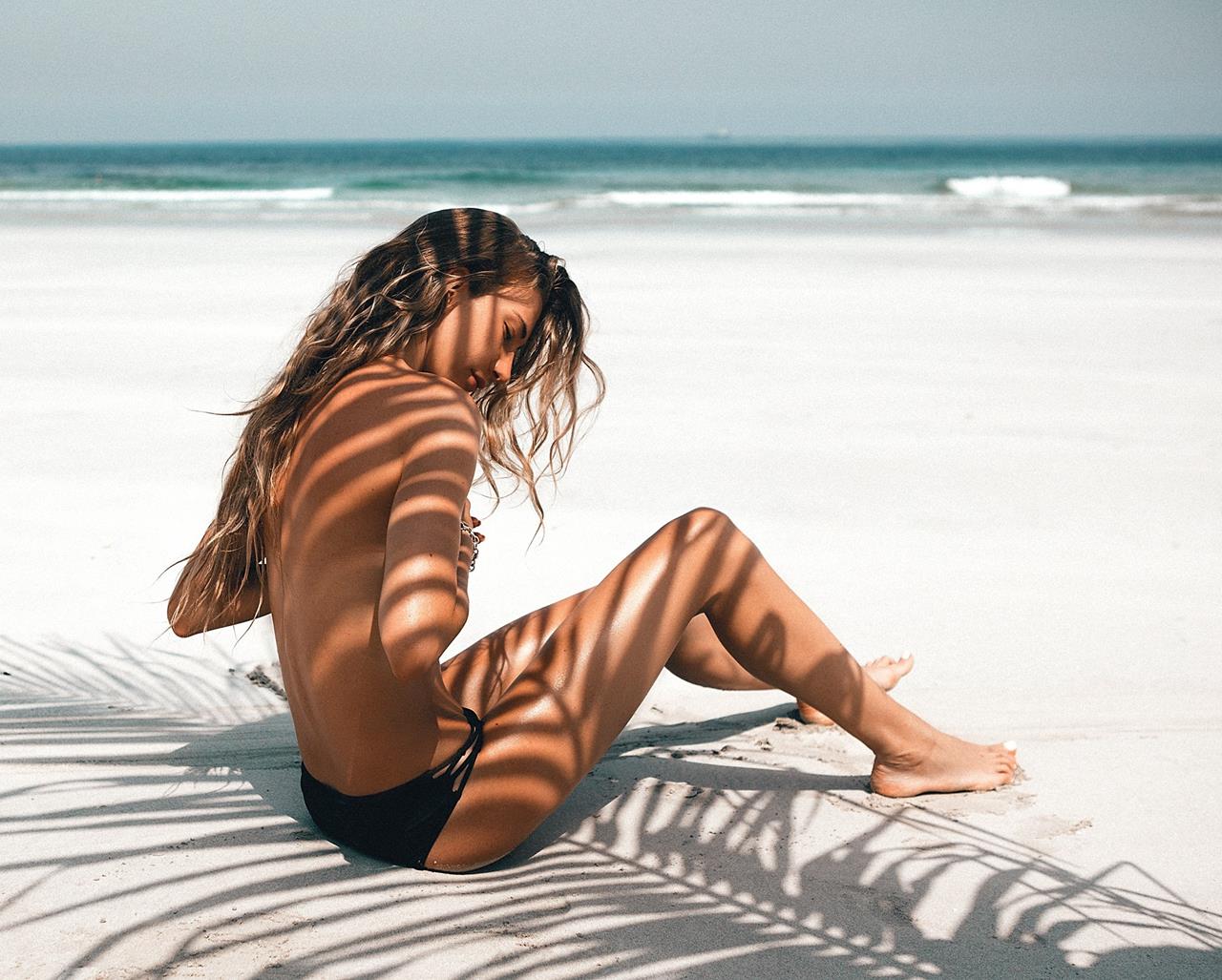 Девушка загорает топлес на пляж